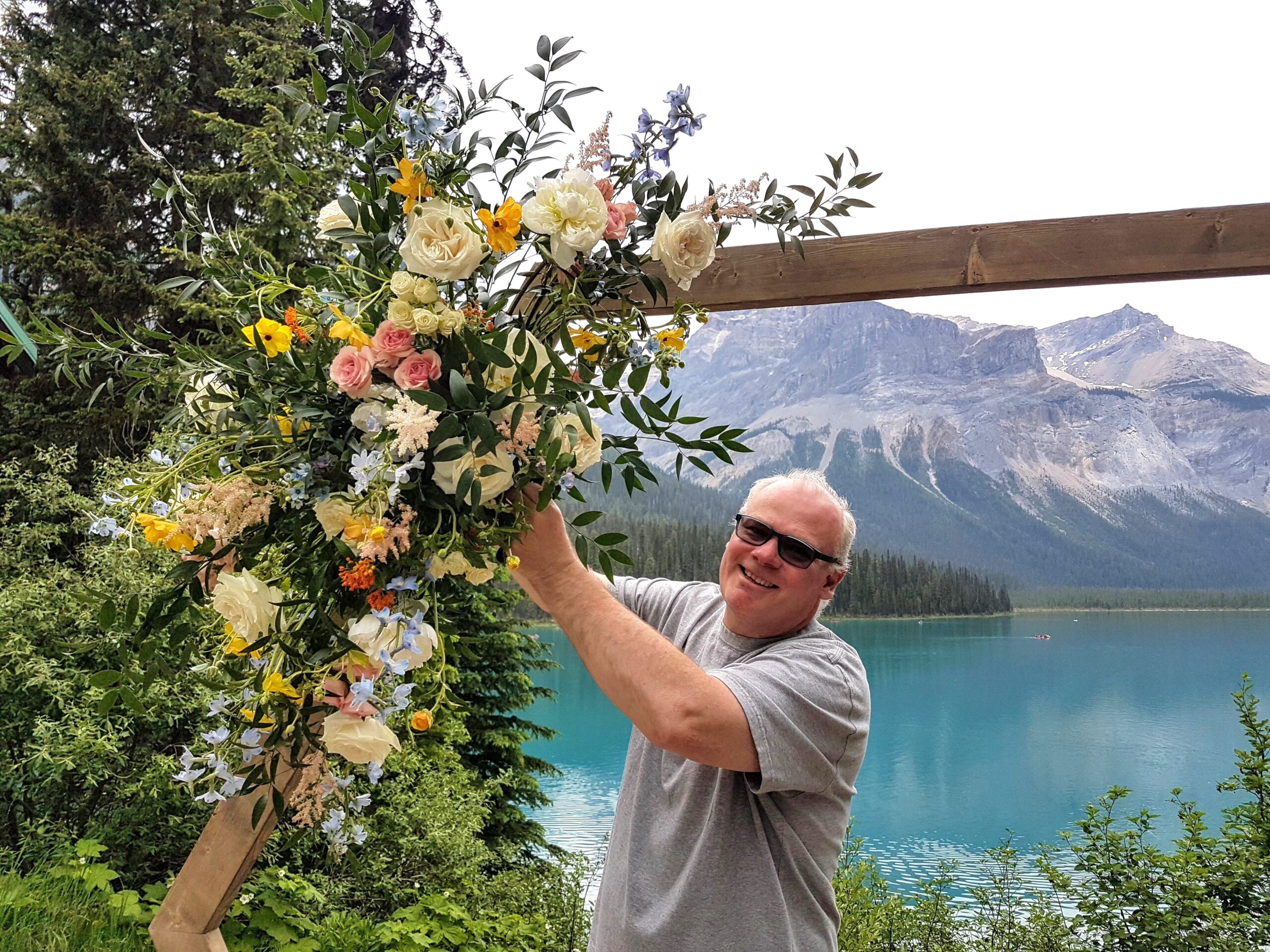 Ralph Dekker, Dutch Florist from Canmore is finishing a colorful arrangement for an arch at Emerald Lake, with an stunning view of the lake