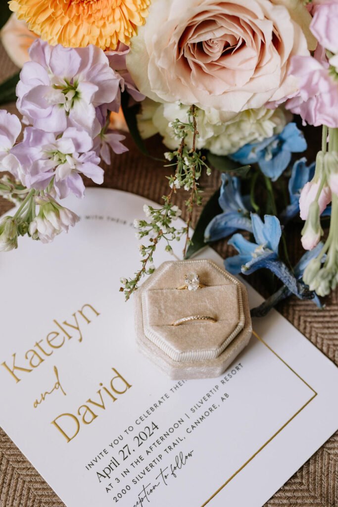 Close-up of a bridal bouquet with soft pastel flowers and wedding rings at a Silvertip Resort wedding in Canmore, Alberta