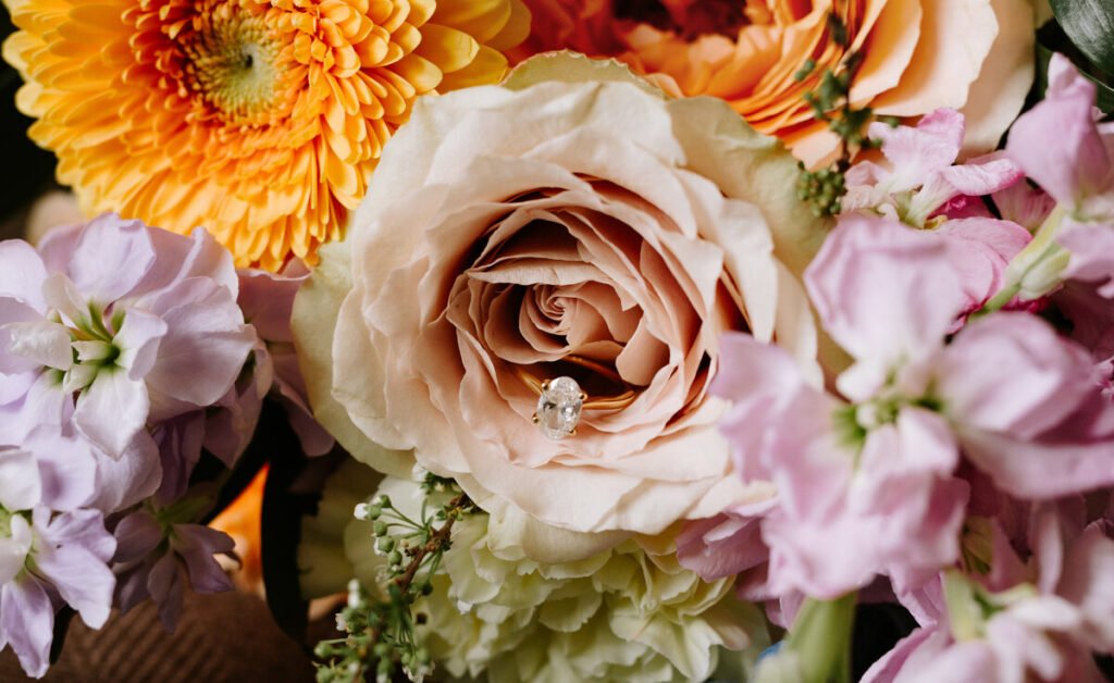 Close-up of a bridal bouquet with soft pastel flowers and wedding rings at a Silvertip Resort wedding in Canmore, Alberta